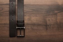 brown leather belt for men on wooden table