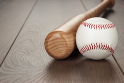 closeup of baseball bat and ball on wooden table with copy space