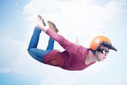 Crazy man in red helmet and goggles is flying in the sky. Jumper concept