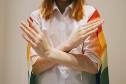 teenage girl generation Z with her arms crossed at her chest and lgbt pride flag demonstrates Break The Bias symbol of international women's day principles of feminism, gender equality and support