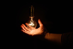 Light bulb and hand, concept of wisdom.
