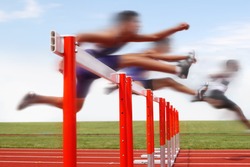 Hurdle race, men jumping over hurdles in a track and field race. Motion blurred image, digitally altered unidentifiable face.