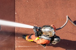 French firefighter with fire hose shot with top-down view