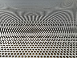 Sheet of a perforated stainless steel ideal for industrial brochures background