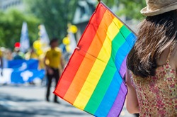 A female spectator is holding the gay rainbow flag at the 2015 Gay Pride Parade in Montreal.