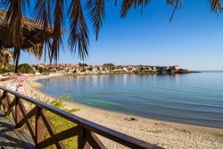 Seaside landscape - view from the cafe to the sandy beach with umbrellas and sun loungers in the town of Sozopol on the Black Sea coast in Bulgaria