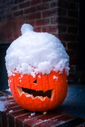 Snow covered Halloween carved pumpkin