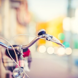 Detail of a Vintage Bike HandleBar with a Colorful Background Bokeh Made of Busy Traffic