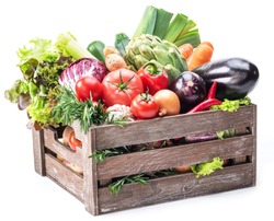 Fresh multi-colored vegetables in wooden crate. White background.