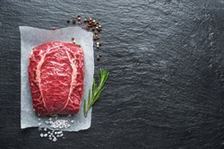 The top blade steak or beef steak on the graphite board with herbs and spices.