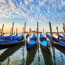 Gondolas in lagoon of Venice on sunrise, Italy