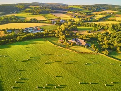 Aerial view of pastures and farmlands in Brittany, France. Beautiful French countryside with green fields and meadows. Rural landscape on sunset
