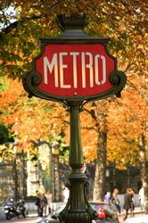 Parisian metro sign with autumn trees in the background