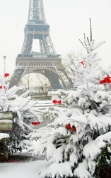 Rare snowy day in Paris. The Eiffel Tower and decorated Christmas tree