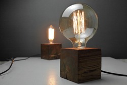 Retro wood lamp with Edison lamp on a gray background. 