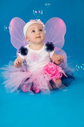 beautiful little fairy on a blue background with soap bubbles