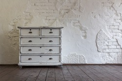 Vintage chest of drawers in the background of the old wall. Vintage interior.