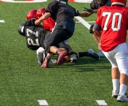 Football player tackled on field during game -American football