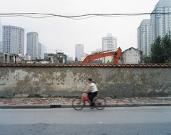 Women riding pass building works in shanghai in motion blur