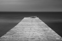 fine art photo of old wooden pier in smooth water with copy space
