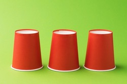 Inverted red paper cups on a green background