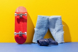 Red fingerboard and toy clothes on a colored background