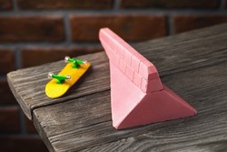 Gypsum ramp in pink color and yellow fingerboard on a wooden table
