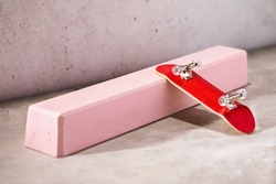 Red fingerboard on a pink gypsum railing on an abstract background