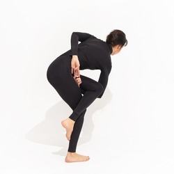 Woman in black sportswear practicing yoga, performs a variation of the vatajanasana exercise, horse pose on a white background