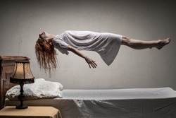 Woman levitating over bed / astral traveling, nightmare, excorcist halloween concept