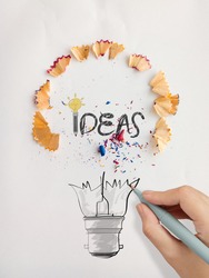hand drawn light bulb word design IDEA with pencil saw dust on paper background as creative concept