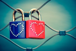 Two grungy love padlocks with heart decoration attached to the bridge in Paris. Valentine's day background. Toned photo. 