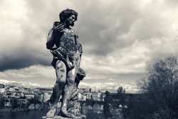View of Albi (France). Statue of Bacchus (Dionysus) with grapes and wine cup at Bishop palace park in Albi (Roussillon-Languedoc) and view of  city and Tarn river with its bridges. Toned photo.