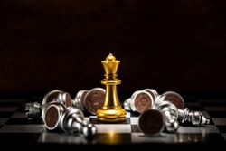 gold queen chess surrounded by a number of fallen silver chess pieces , business strategy concept