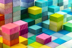 Spectrum of stacked multi-colored wooden blocks. Background or cover for something creative, diverse, expanding,  rising or growing. shallow depth of field.