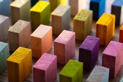 Spectrum of colorful wooden blocks aligned on a rustic old wood table. Japanese Color set.  Background or cover for something creative, diverse, and in multiple variations. Shallow depth of field