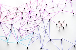 Linking entities. Networking, social media, SNS, internet communication abstract. Small network connected to a larger network. Web of light to dark blue, red, purple, gold wires on white background. 