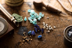 Exploring mining, and inspecting gems. Treasure hunting. Gold and gems on rough wooden surface.