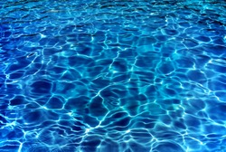 Resort pool water ripples in evening.