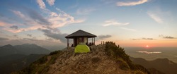romantic sunset scenery at herzogstand mountain, pavilion and camping tent at the summit. bavarian alps.