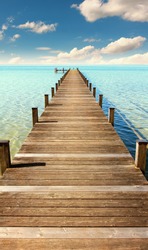 boardwalk to the horizon, turquoise water and blue sky with clouds, paradise landscape