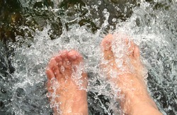 women feet, refreshing and hardening in a cool mountain brook
