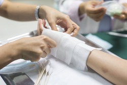 Health care series : Closeup of hands of nurse dressing wound for patient's hand with burn injury