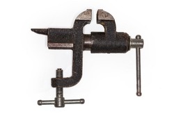 Old home bench vise with small anvil on the back and fastening to the workbench with screw clamp, side view on a white background