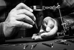 Pocket watch being repaired by senior watch maker, close-up. Black and white.
