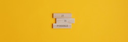 It is possible sign on stacked wooden pegs placed over yellow background. Wide view image with copy space. 