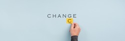 Wide view image of male hand changing the word Change into Chance in a conceptual image. Over light blue background with copy space.