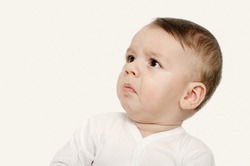 Cute baby boy looking up upset. Baby looking sad. Isolated on white.