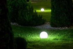 illumination backyard light garden with electric ground lantern with sphere diffuser lamp in the green grass lawn in outdoor park with landscaping, dark patio illuminate night scene nobody.