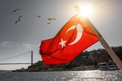 The Turkish flag waving over the Bosphorus. Istanbul Bosphorus bridge, July 15 bridge in the background